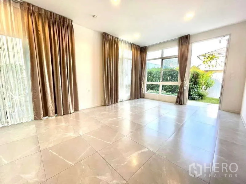 บ้าน ให้เช่าในPrawet, Bangkok - โถงนั่งเล่นแบบเปิดโล่ง มีหน้าต่างบานใหญ่หลายด้าน พื้นกระเบื้องและวิวสวน.