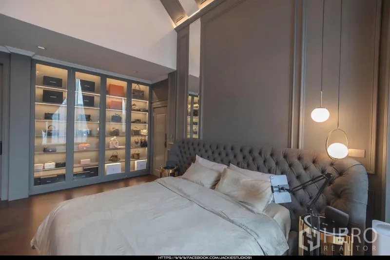 Detached House for sale in Pak Kret, Nonthaburi - Master bedroom with tufted headboard, pendant lights and illuminated glass display wardrobes.