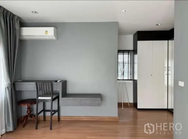 Detached House for rent in Bueng Kum, Bangkok - Bright study corner with built-in desk, air conditioner and wood floors in a bedroom.