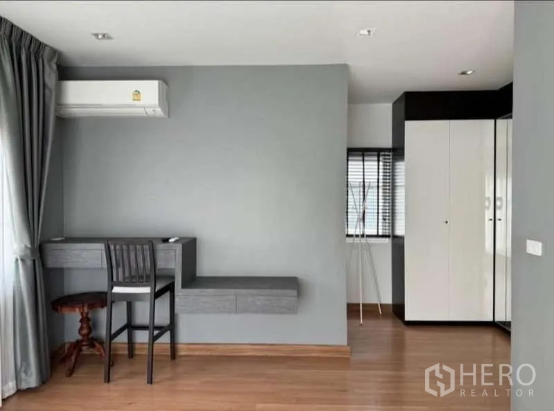 Detached House for rent in Bueng Kum, Bangkok - Bright study corner with built-in desk, air conditioner and wood floors in a bedroom.