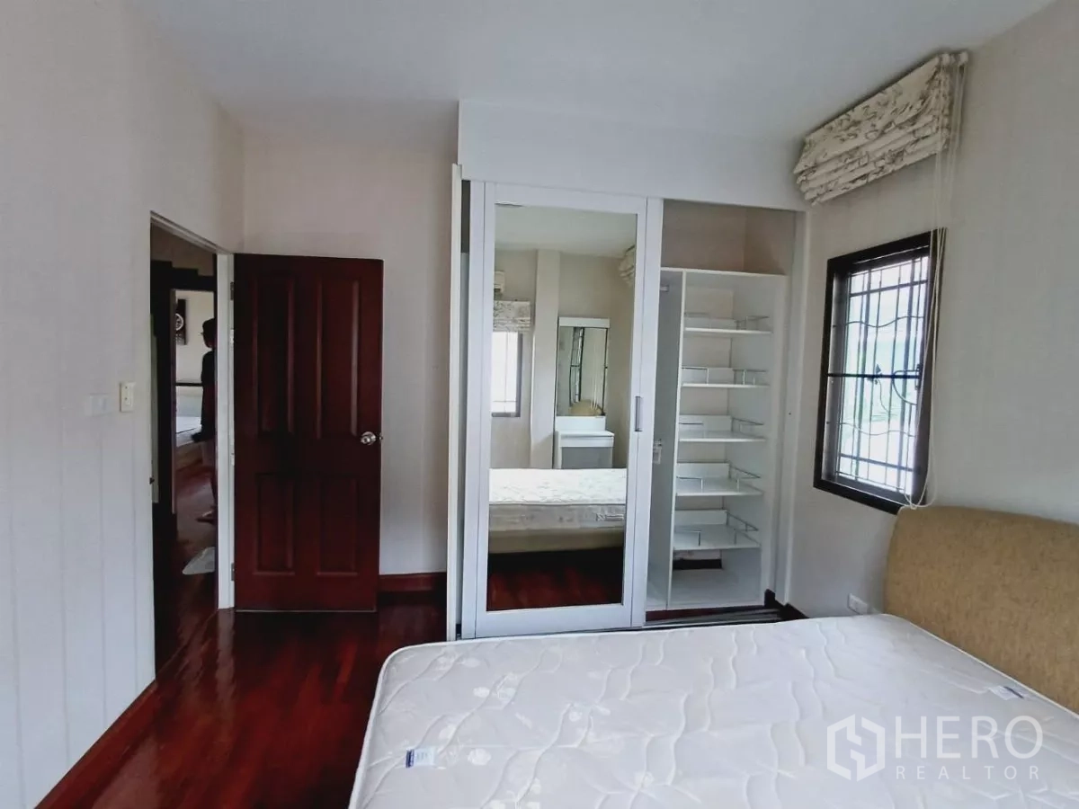 独立式住宅 出租或出售在Mueang Nonthaburi, Nonthaburi - 卧室配镜面推拉门衣柜与开放式置物架。