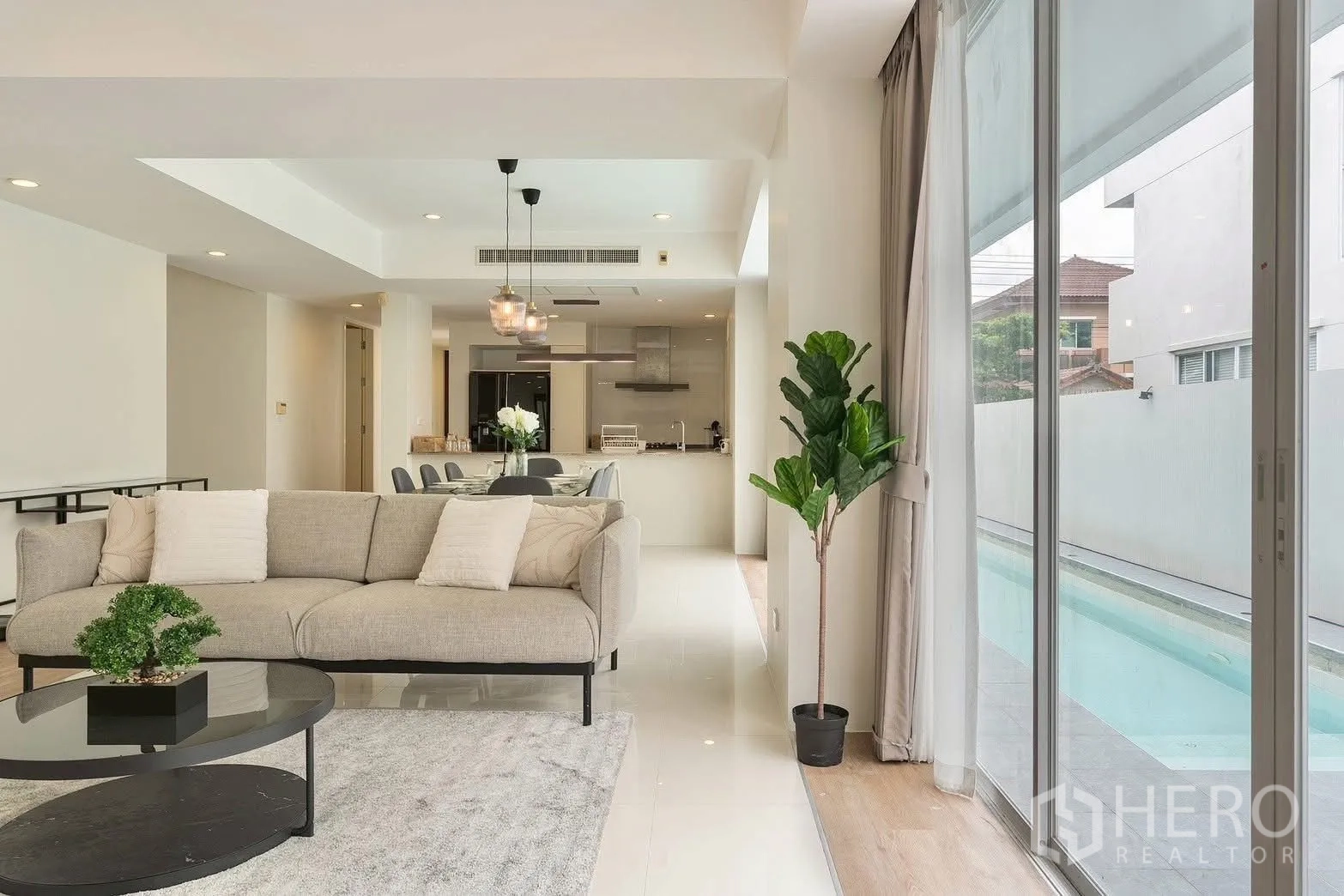 独栋房屋 for rent in Saphan Sung, Bangkok - 客厅眺望池畔露台与用餐空间。