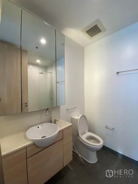 Condominium for rent or sale in Yan Nawa, Bangkok - Modern bathroom with vanity, round basin, mirrored cabinet and toilet.