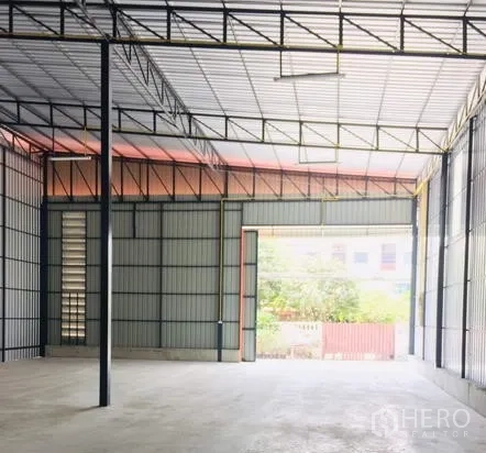 货栈 出租在Bang Kapi, Bangkok - 宽敞仓库内部，高钢桁架屋顶、混凝土地面与宽大装卸门，方便卡车进出。