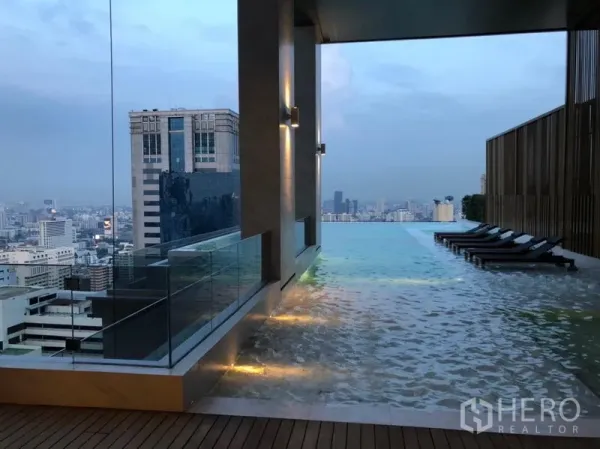 Condominium for rent or sale in Watthana, Bangkok - Rooftop infinity pool with sun loungers and panoramic Bangkok skyline views