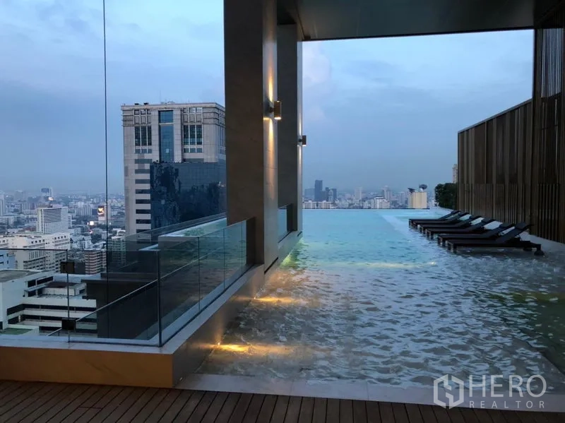 Condominium for rent or sale in Watthana, Bangkok - Rooftop infinity pool with sun loungers and panoramic Bangkok skyline views