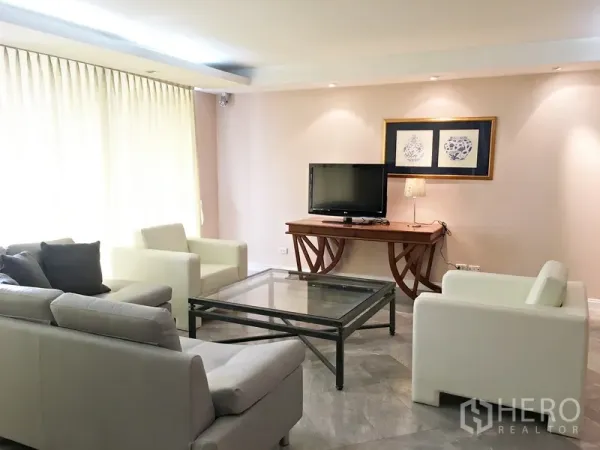 คอนโด ให้เช่าในPathum Wan, Bangkok - ห้องนั่งเล่นสว่าง โซฟาสีอ่อน โต๊ะกระจก และมุมวางทีวี