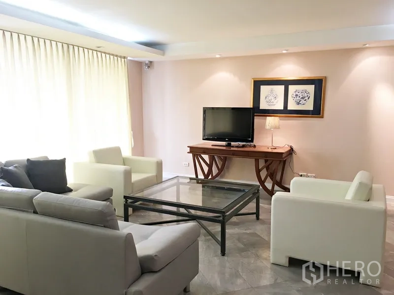 คอนโด ให้เช่าในPathum Wan, Bangkok - ห้องนั่งเล่นสว่าง โซฟาสีอ่อน โต๊ะกระจก และมุมวางทีวี