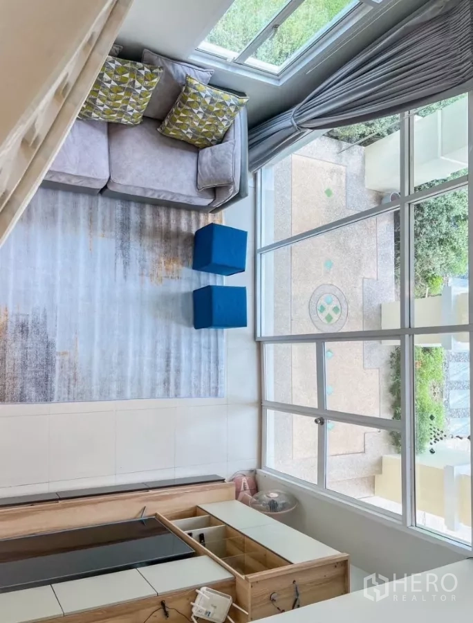 Detached House for rent or sale in Prawet, Bangkok - Top-down view from the mezzanine overlooking the airy living room and tall windows.