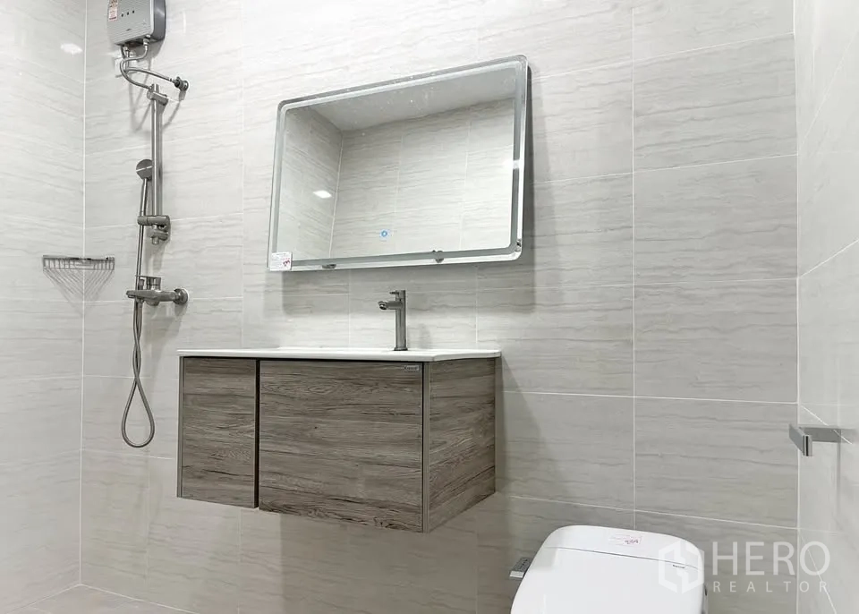 Home Office for rent in Watthana, Bangkok - Bright bathroom with rain shower, wall-hung vanity and light tiles.
