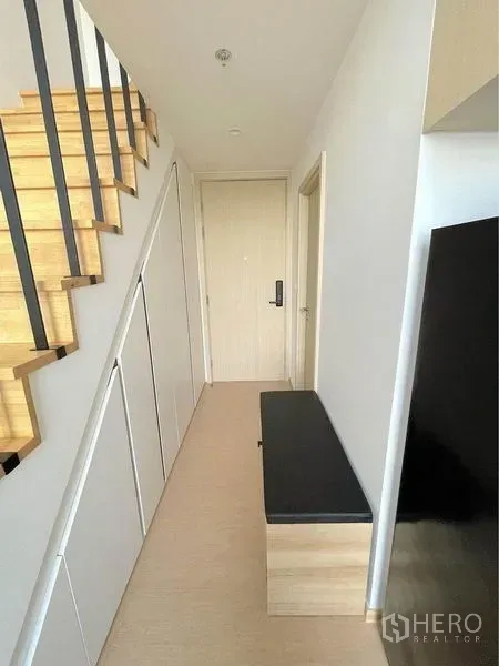 Condominium for rent in Watthana, Bangkok - Entry corridor with light-wood staircase, built-in storage, and bench seating.