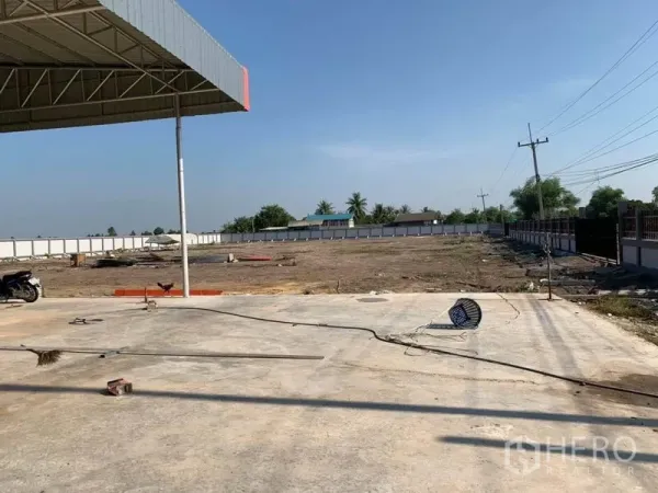 Warehouse for sale in Phra Nakhon Si Ayutthaya - Expansive open yard and concrete apron beside the warehouse, ideal for trailer turning and outdoor storage.