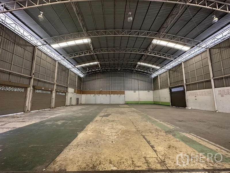 工厂 出租在Phra Nakhon Si Ayutthaya - 从另一端看清晰大跨仓库，高净空，通风墙体与多道卷闸门。