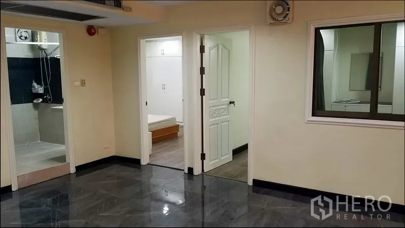 公寓 出租或出售在Khlong Toei, Bangkok - 走廊铺亮面地砖，通往卧室与带淋浴间的浴室。