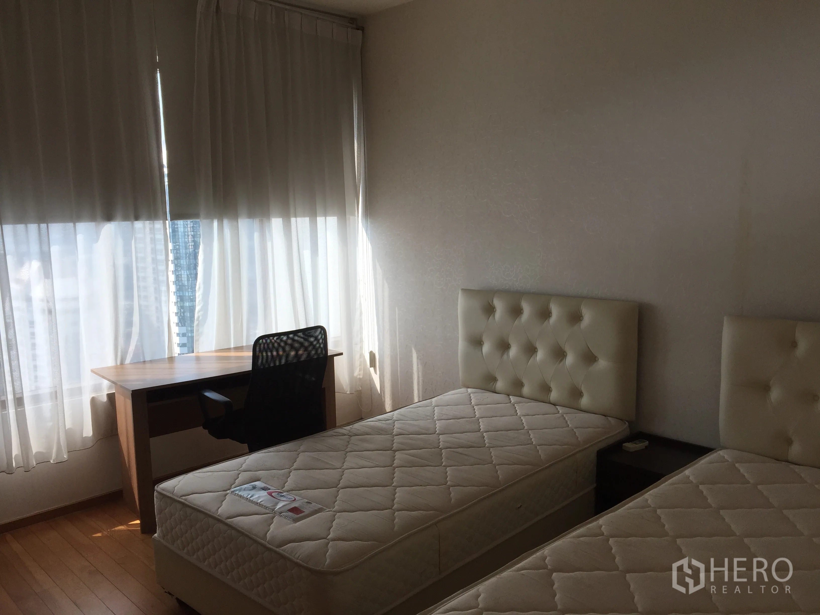 คอนโด ให้เช่าหรือขายในKhlong Toei, Bangkok - ห้องนอนที่สองมีเตียงคู่ โต๊ะทำงาน พื้นไม้ และหน้าต่างขนาดใหญ่พร้อมผ้าม่านสีอ่อน