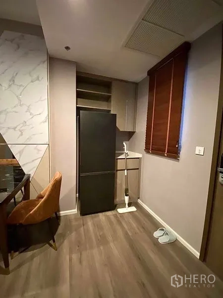 Condominium for rent in Phra Khanong, Bangkok - Pantry corner with tall refrigerator, small sink and a window with blinds.