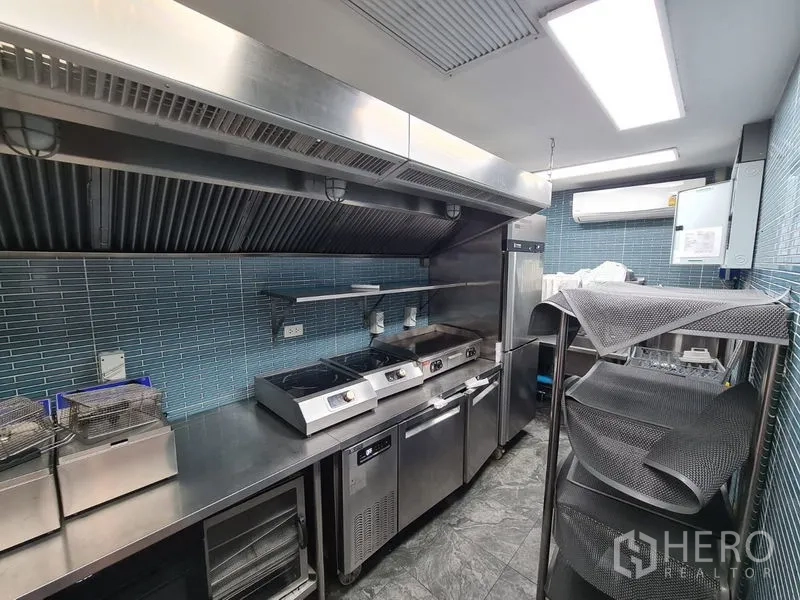 零售空间 出租在Bang Rak, Bangkok - 不锈钢商用厨房，带排烟罩、油炸炉与备餐台。