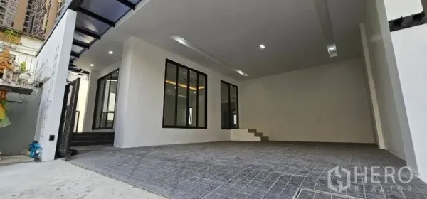 Home Office for rent in Khlong Toei, Bangkok - Wide covered parking area with tiled floor, windows and steps to the interior.