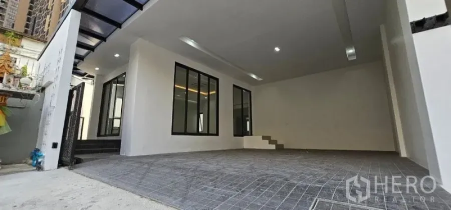 Home Office for rent in Khlong Toei, Bangkok - Wide covered parking area with tiled floor, windows and steps to the interior.