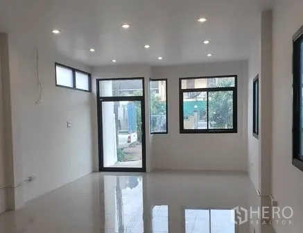 Warehouse for rent or sale in Lam Luk Ka, Pathum Thani - Ground-floor office room with glossy tile floor, recessed downlights and multiple windows.