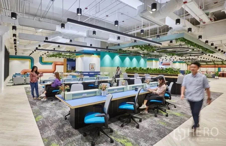 办公空间 出租在Pathum Wan, Bangkok - 开放式联合办公区，共享长桌、拼接地毯与圆环吊灯。