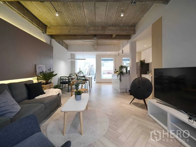 ทาวน์เฮาส์ ให้เช่าในWatthana, Bangkok - ห้องนั่งเล่นกว้าง โซฟา ทีวี และพื้นที่ทานอาหาร ใต้เพดานคอนกรีตเปลือย