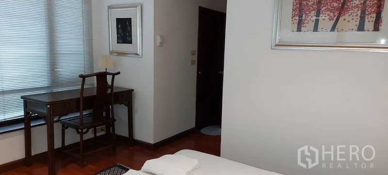 คอนโด ให้เช่าในSathon, Bangkok - มุมห้องนอนพร้อมโต๊ะทำงานริมหน้าต่างและรูปภาพบนผนังสีอ่อน