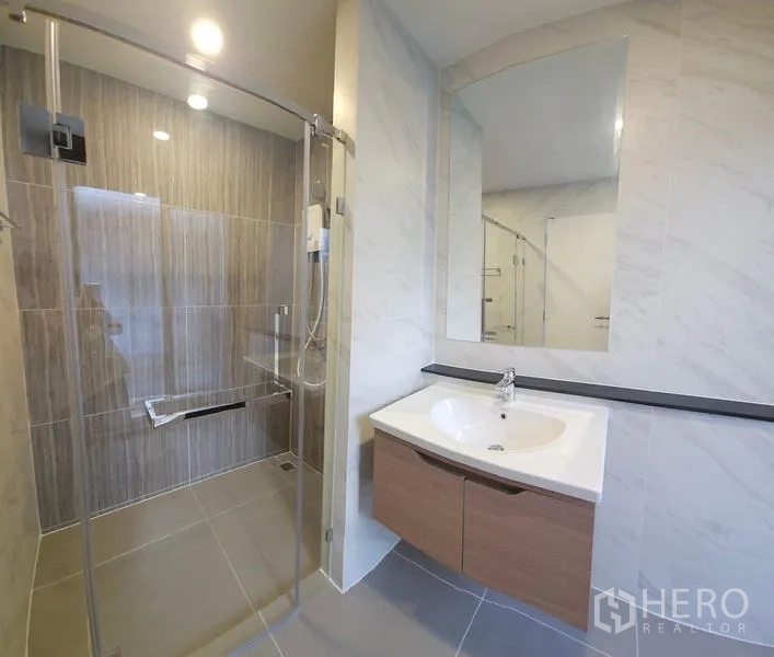 บ้าน ให้เช่าในSaphan Sung, Bangkok - ห้องน้ำสไตล์โมเดิร์นพร้อมตู้กระจกอาบน้ำ กระจกบานใหญ่ และอ่างล้างหน้าแขวน.