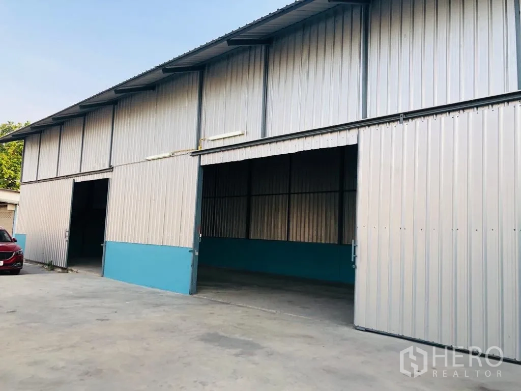 คลังสินค้า ให้เช่าในSaphan Sung, Bangkok - ด้านนอกโกดังกรุ๊ปเมทัลชีท ประตูบานเลื่อนขนาดใหญ่เปิดอยู่ พร้อมลานคอนกรีตสำหรับขนถ่ายและจอดรถ