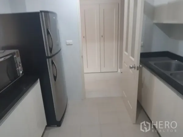 คอนโด ให้เช่าในKhlong Toei, Bangkok - มุมครัวพร้อมตู้เย็นสองประตู ไมโครเวฟ และอ่างล้างจานคู่ เชื่อมต่อสู่โถงทางเดิน