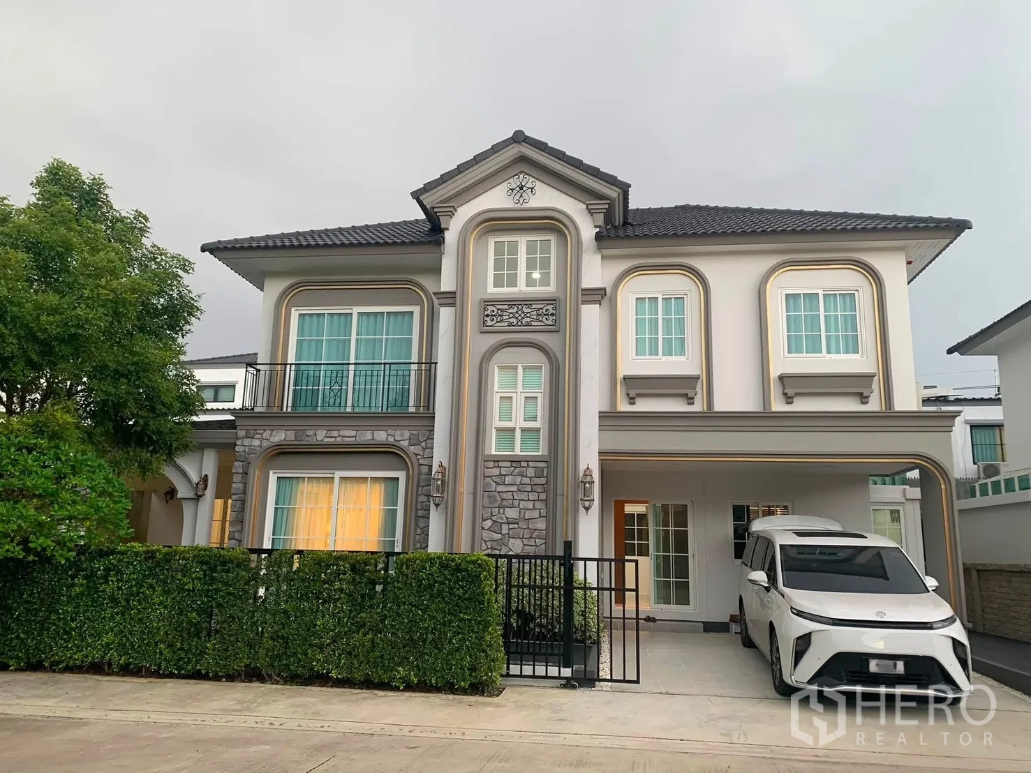 Detached House for rent in Bang Phli, Samut Prakan - Two-storey detached house exterior with gated hedge and a covered carport.