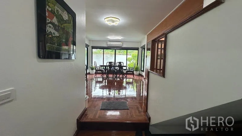 独立式住宅 出租在Watthana, Bangkok - 走廊通向餐区，落地窗面向花园。