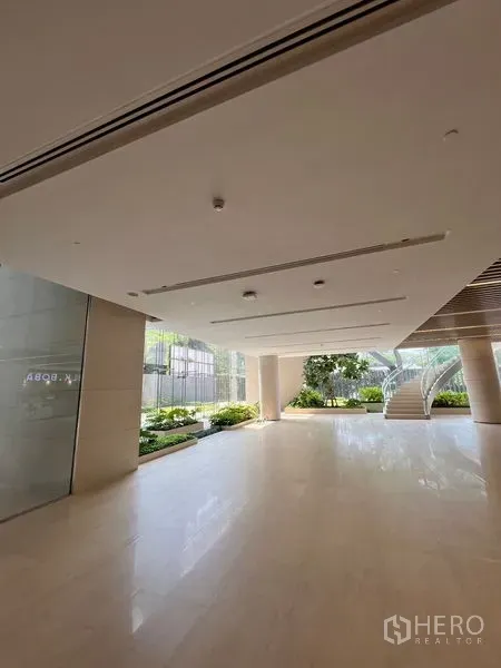 零售空间 出租 - 开放式门厅，光泽地砖、整面玻璃墙、室内绿植与楼梯连通。