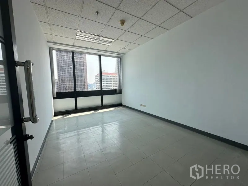Office Space for rent in Khlong Toei, Bangkok - Private room with large windows and glass door, ready for workstation setup.