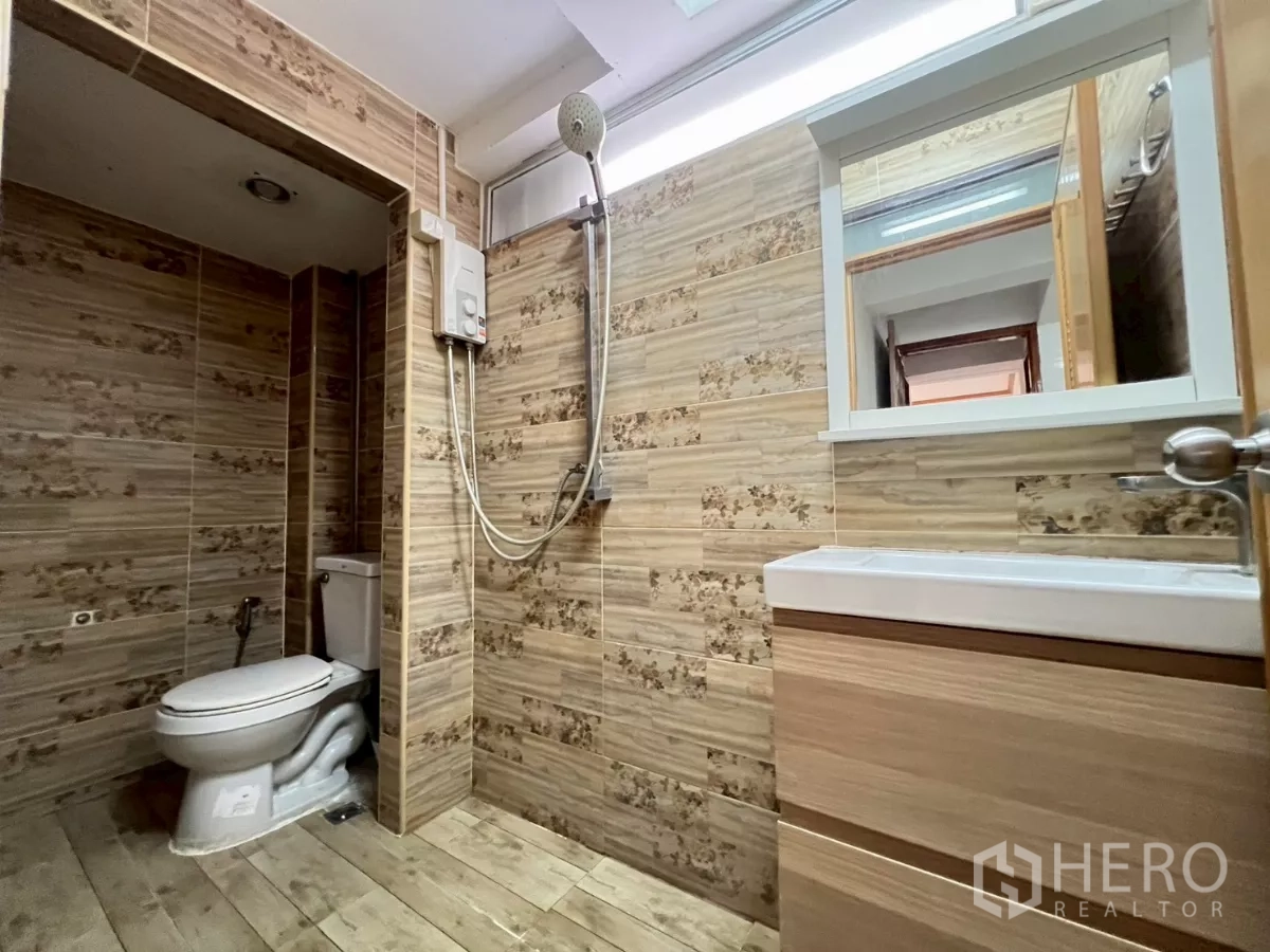 Home Office for rent in Watthana, Bangkok - Bathroom with wood-look tiles, shower and modern vanity.