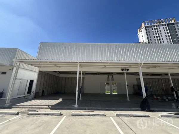 Warehouse for rent in Min Buri, Bangkok - Covered loading bay with open frontage and lined car parking spaces in front.