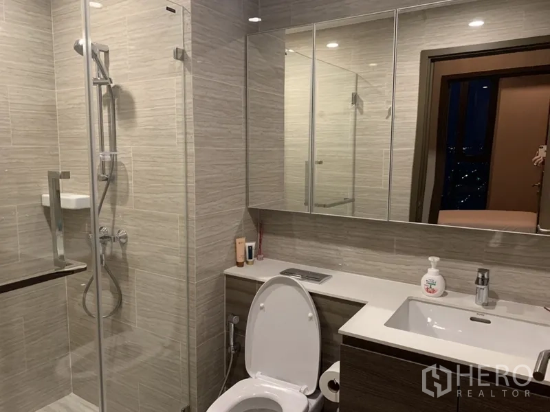 คอนโด ขายในPhra Khanong, Bangkok - ห้องน้ำสว่าง เคาน์เตอร์อ่างล้างหน้าและตู้กระจก พร้อมฝักบัวกระจกกั้น