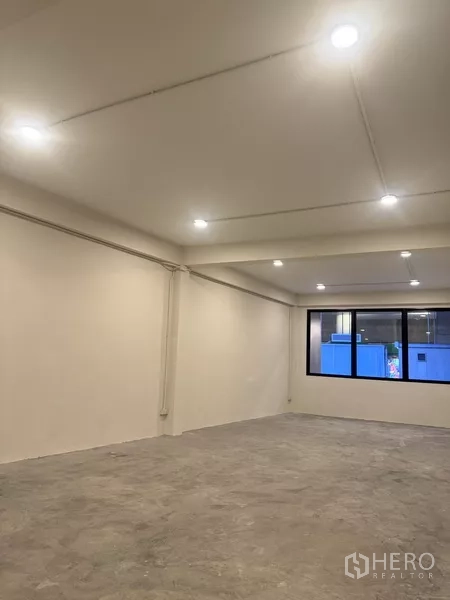 อาคารพาณิชย์ ให้เช่า - ห้องรูปทรงสี่เหลี่ยมกว้าง มีหน้าต่างและไฟเพดาน พื้นคอนกรีต