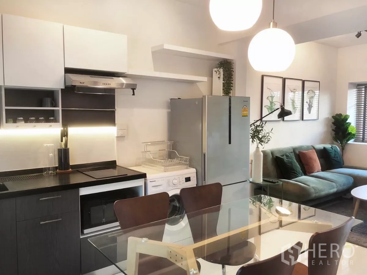 Townhouse for rent or sale in Bang Phli, Samut Prakan - Kitchen and living area view showing cabinetry, appliances and L-shaped sofa.