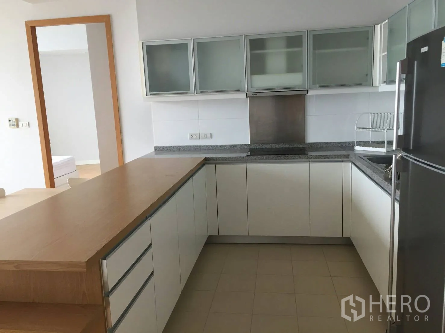คอนโด ให้เช่าหรือขายในKhlong Toei, Bangkok - ครัวรูปตัว U โทนขาว เคาน์เตอร์หินแกรนิตและตู้เย็นขนาดใหญ่
