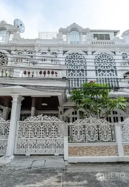 ทาวน์เฮาส์ ให้เช่าในWatthana, Bangkok - ด้านหน้าทาวน์เฮ้าส์สีขาวลวดลายฉลุและระเบียงหลายชั้น
