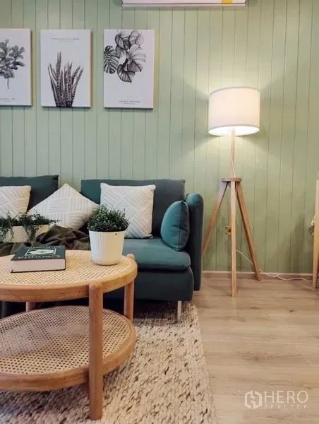 公寓 出租或出售 - 客厅绿色特色墙，蓝绿色沙发，藤编茶几与三脚落地灯。