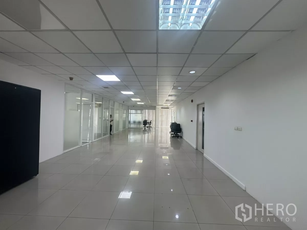 Office Space for rent in Huai Khwang, Bangkok - Spacious open-plan office corridor with glass-partitioned rooms, glossy tiles and grid ceiling lights.