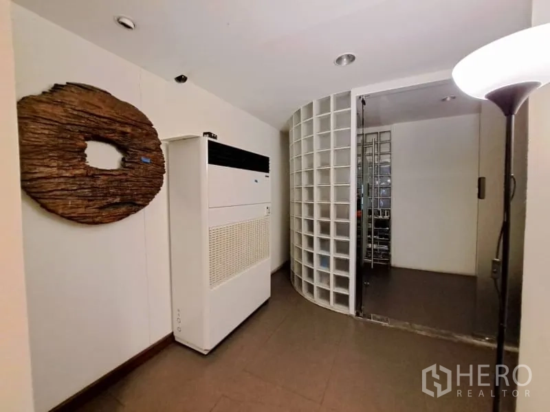 店屋 出租在Watthana, Bangkok - 走廊设空调与弧形玻璃砖墙，通往储物间。