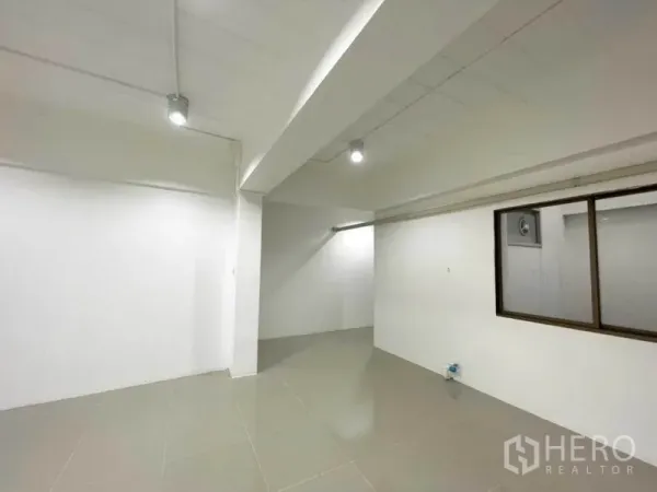 办公空间 出租在Khlong Toei, Bangkok - 办公室转角，白墙、梁柱与通向内室的窗。