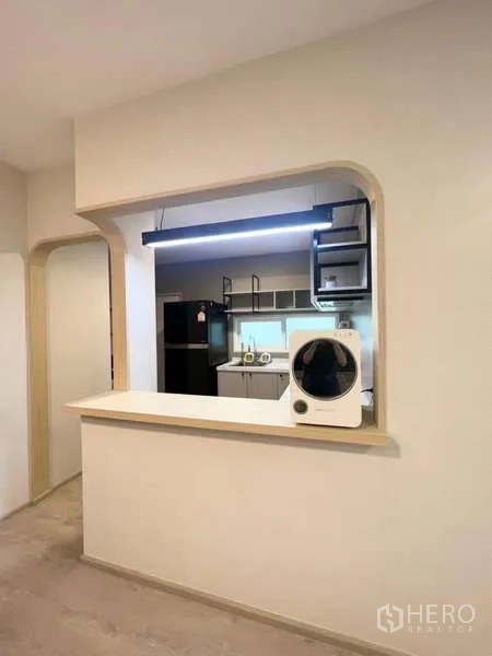 Detached House for rent in Prawet, Bangkok - Kitchen pass-through window with pendant light looking into a fitted kitchen.