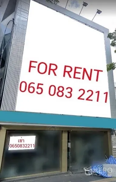 อาคารพาณิชย์ ให้เช่าในKhlong Toei, Bangkok - ด้านหน้าอาคารพาณิชย์สมัยใหม่พร้อมป้ายโฆษณาขนาดใหญ่และหน้ากระจก.