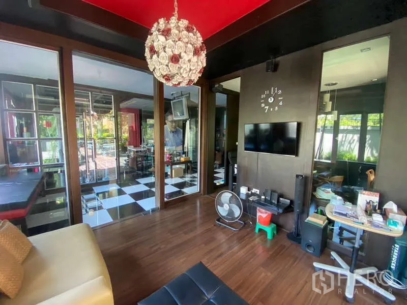 Detached House for sale in Suan Luang, Bangkok - Media room with wall-mounted TV, wood floors and designer pendant light.