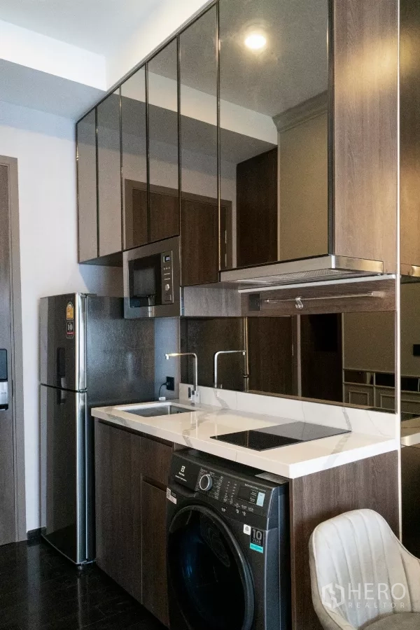 公寓 出租在Watthana, Bangkok - 现代厨房，石英台面，电磁炉、水槽、冰箱和洗烘一体机。