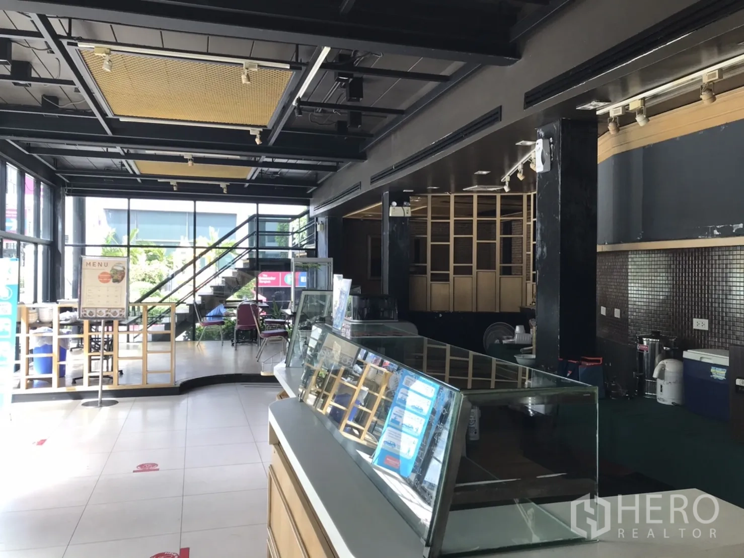 พื้นที่ขายปลีก ให้เช่าในKhlong Toei, Bangkok - โถงค้าปลีกชั้นล่างพร้อมตู้โชว์ บันไดขึ้นชั้นบน และกระจกบานกว้าง